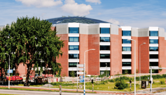 EDGE Amsterdam West, een duurzaam gerenoveerd kantoorgebouw met een opvallend glazen dak, energiezuinige installaties en een groene omgeving in Amsterdam.