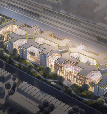 Luchtfoto van het nieuwe ABN AMRO-hoofdkantoor in Amsterdam met moderne architectuur en veel glazen panelen.