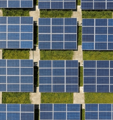Luchtfoto van PV panelen op een veld, symboliserend duurzame energieopwekking en milieuvriendelijke technologie.