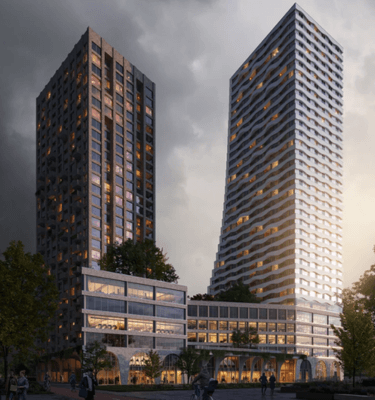 Avondzicht op The Ensemble, twee moderne torens met een uniek design en duurzaam karakter in een stedelijke omgeving.