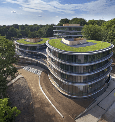 Triodos Bank in Driebergen-Rijsenburg, een circulair en duurzaam kantoor met organische vormen, grote glazen gevels en groene daken, omgeven door natuur.