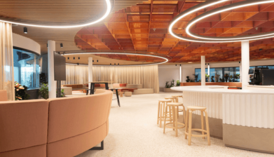 Modern interieur van EDGE Stadium met ronde LED-verlichting, houten plafondelementen en een open, uitnodigende werkruimte.