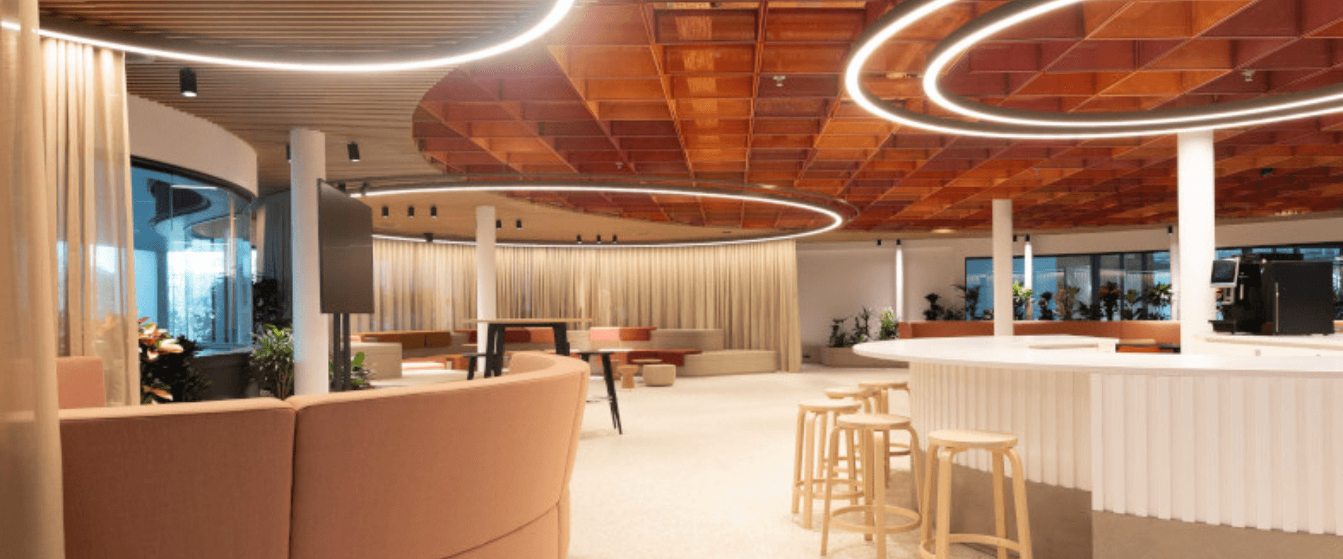 Modern interieur van EDGE Stadium met ronde LED-verlichting, houten plafondelementen en een open, uitnodigende werkruimte.
