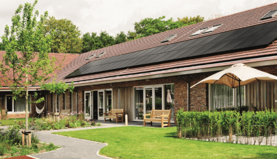 Het Jeroen Pit Huis in Amsterdam, een duurzaam zorggebouw met een groene tuin, zonnepanelen op het dak en een huiselijke uitstraling.