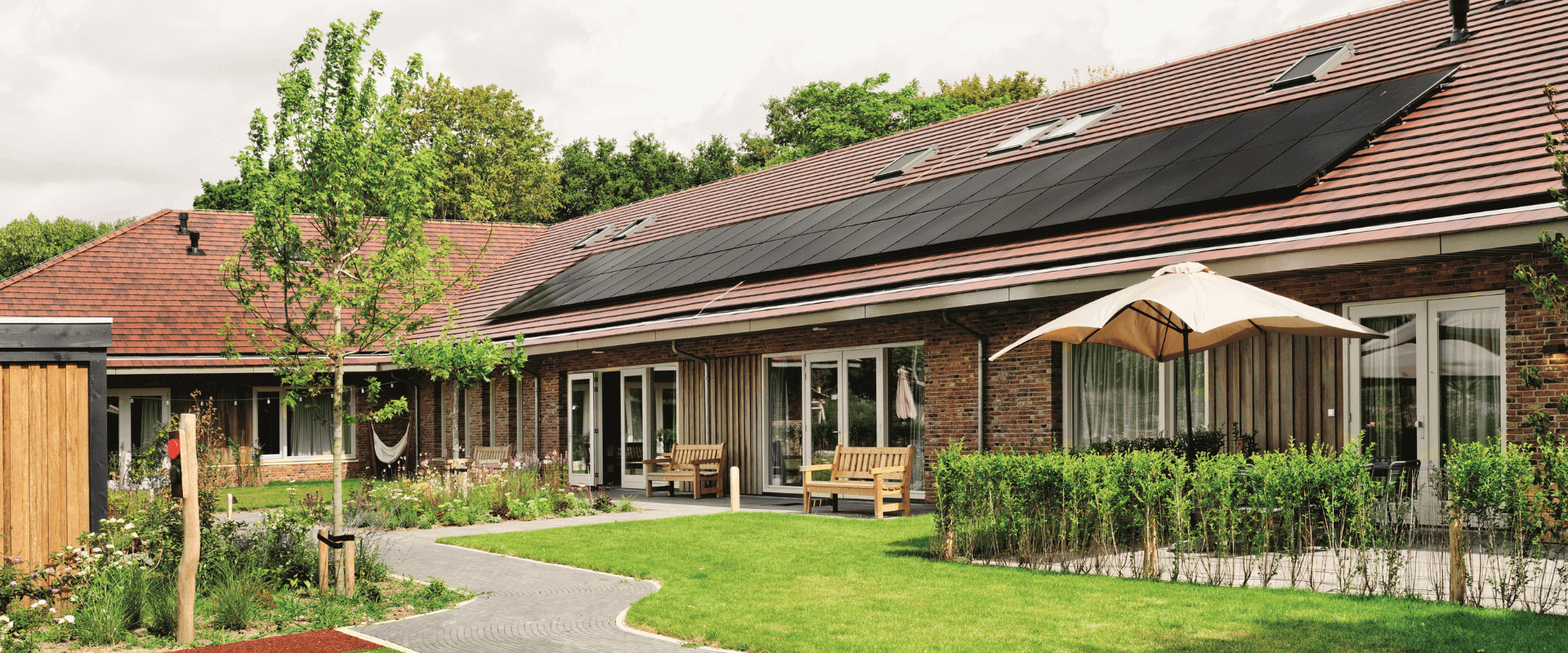 Het Jeroen Pit Huis in Amsterdam, een duurzaam zorggebouw met een groene tuin, zonnepanelen op het dak en een huiselijke uitstraling.