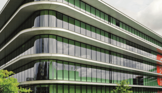 ING Headquarters in Amsterdam, een modern en duurzaam kantoorgebouw met afgeronde hoeken, grote glazen gevels en groene accenten in een parkachtige omgeving.