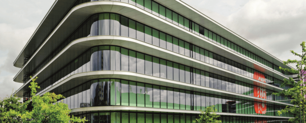 ING Headquarters in Amsterdam, een modern en duurzaam kantoorgebouw met afgeronde hoeken, grote glazen gevels en groene accenten in een parkachtige omgeving.