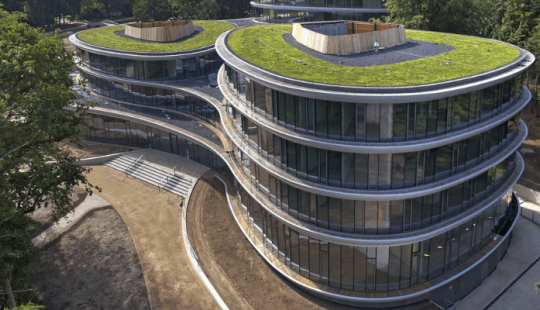 Triodos Bank in Driebergen-Rijsenburg, een circulair en duurzaam kantoor met organische vormen, grote glazen gevels en groene daken, omgeven door natuur.