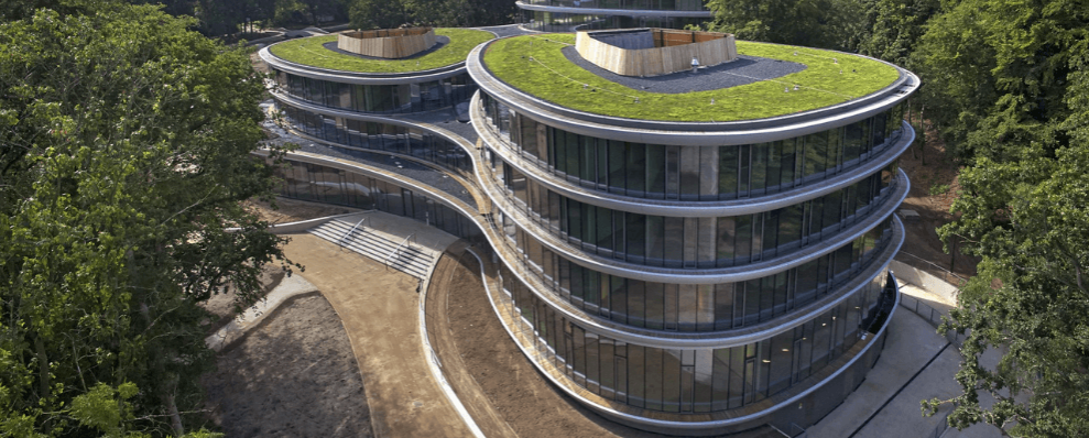 Triodos Bank in Driebergen-Rijsenburg, een circulair en duurzaam kantoor met organische vormen, grote glazen gevels en groene daken, omgeven door natuur.