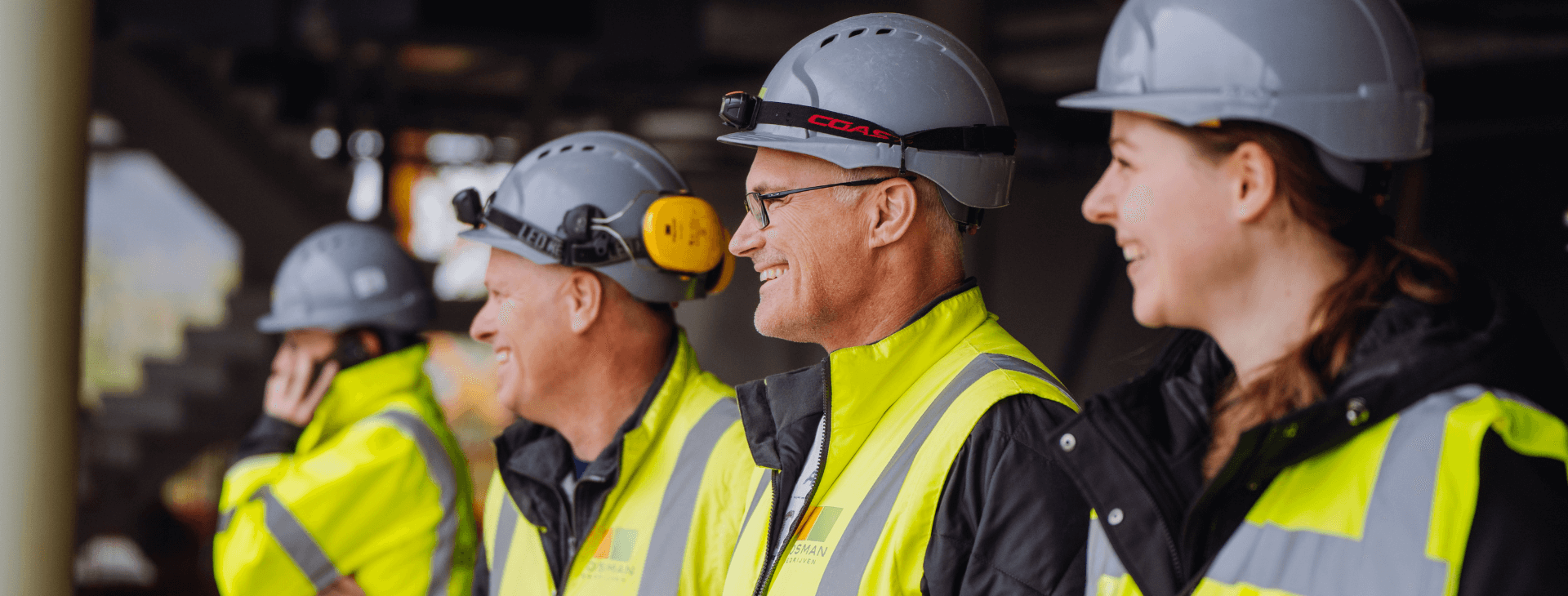 Een groep enthousiaste Bosman-medewerkers op een bouwlocatie, gekleed in veiligheidskleding en helmen. Ontdek het werken bij Bosman en word onderdeel van een hecht en innovatief team.
