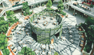 Licht en ruim atrium van EDGE Amsterdam West met groen begroeide centrale structuur, omringd door zitplaatsen en een glazen dakconstructie.