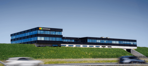 Het nieuwe pand van Bosman Installatietechniek, een modern gebouw met veel glas en groen langs de snelweg A1.