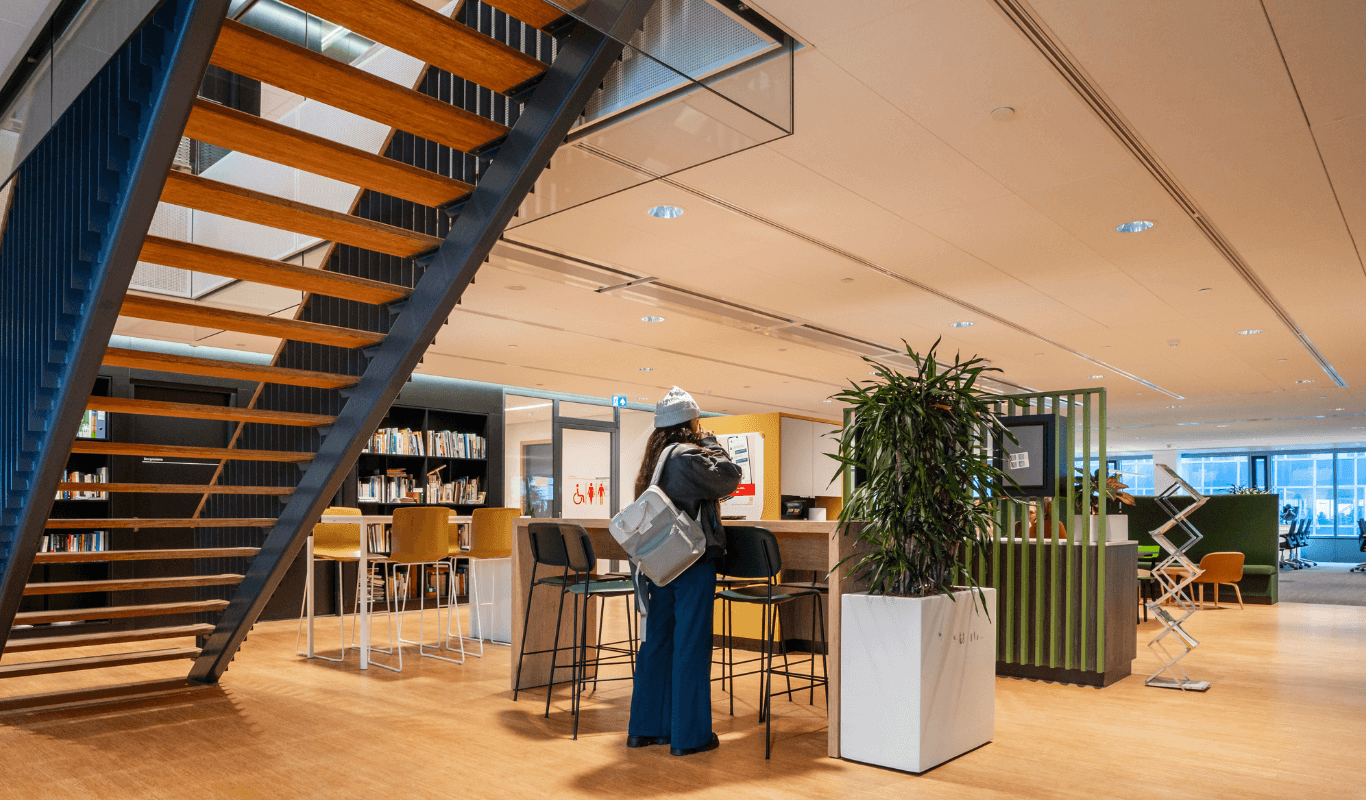 Moderne hybride werkomgeving in het Stadskantoor Utrecht met open trap, flexwerkplekken en duurzame inrichting.