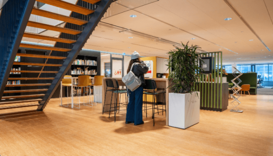 Moderne hybride werkomgeving in het Stadskantoor Utrecht met open trap, flexwerkplekken en duurzame inrichting.