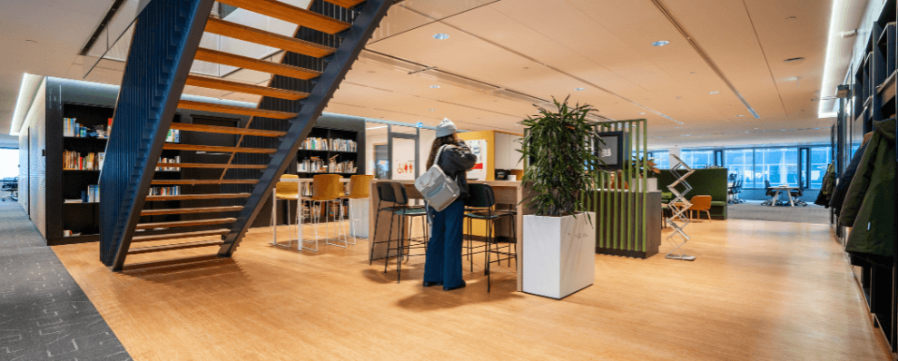 Moderne hybride werkomgeving in het Stadskantoor Utrecht met open trap, flexwerkplekken en duurzame inrichting.