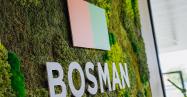 Wand met mos, het Bosman-logo en een kleurrijk vlak in de entree van het kantoor.