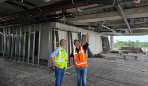 Twee bouwprofessionals in veiligheidskleding bespreken installaties bij een project.