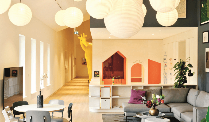 Gezellige en kindvriendelijke lounge met zithoek, ronde hanglampen en speelhuisje in Het Jeroen Pit Huis.