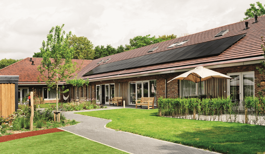 Het Jeroen Pit Huis in Amsterdam, een duurzaam zorggebouw met een groene tuin, zonnepanelen op het dak en een huiselijke uitstraling.
