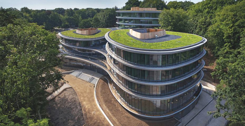 Triodos Bank in Driebergen-Rijsenburg, een circulair en duurzaam kantoor met organische vormen, grote glazen gevels en groene daken, omgeven door natuur.