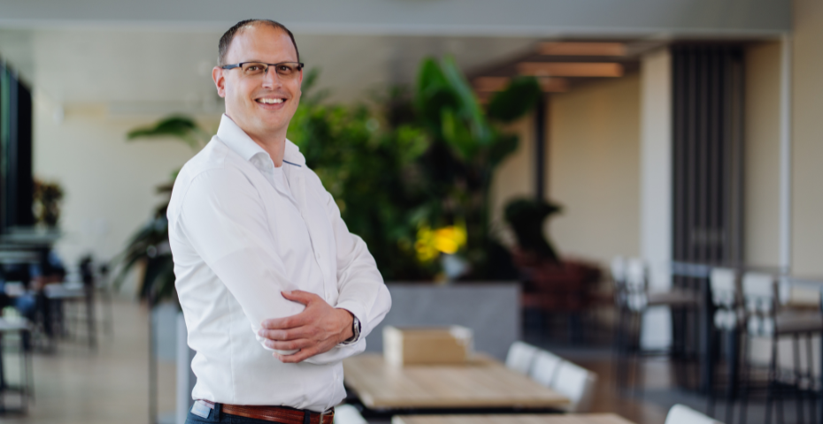 Lachende mannelijke collega die poseert in een ruimte